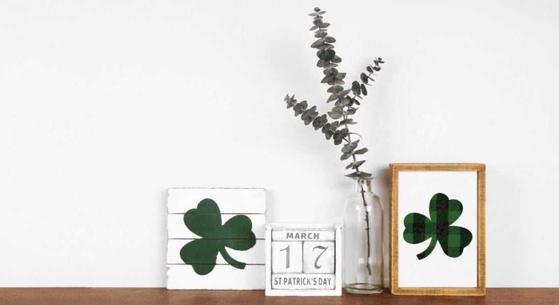 A calendar with the date 17th of March sits on a desk next to two drawings of a shamrock and a thin plant.