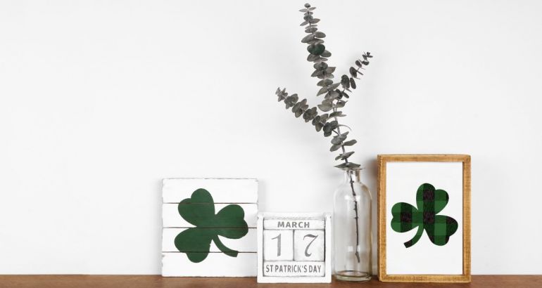 A calendar with the date 17th of March sits on a desk next to two drawings of a shamrock and a thin plant.