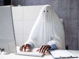 A man sits at a computer working on his role as a software engineer.