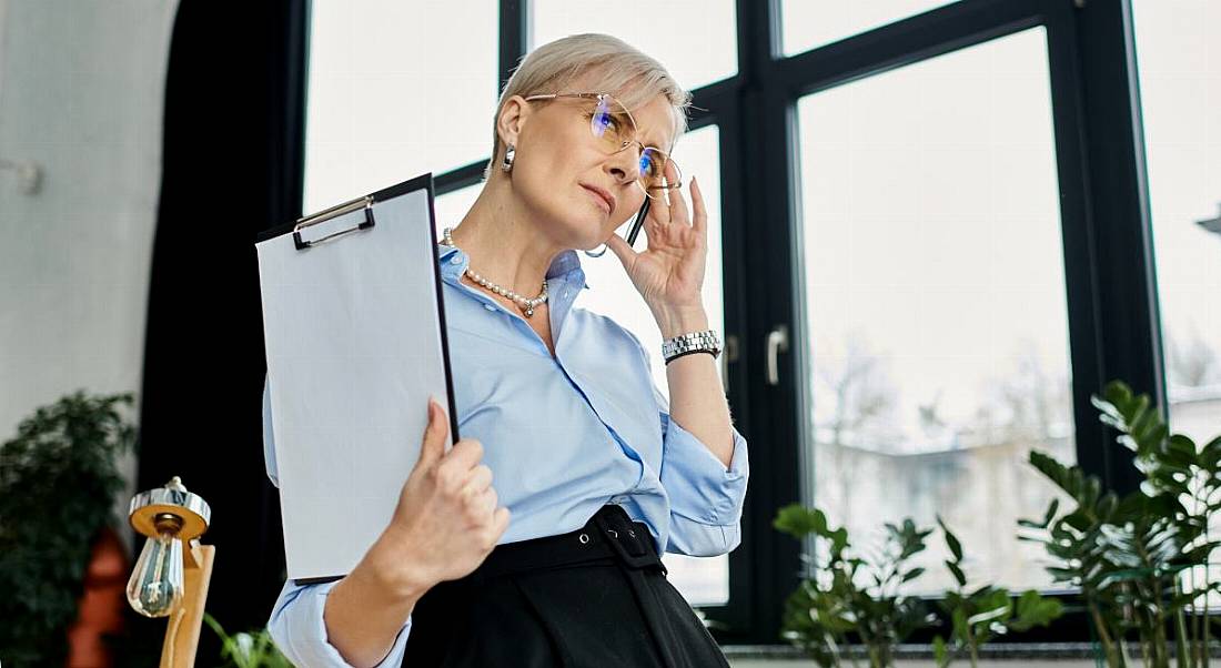 An older woman manages symptoms of the menopause in the workplace.