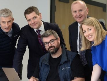 Four men and one woman smile with each other at the opening of the Dublin CalypsoAI office.