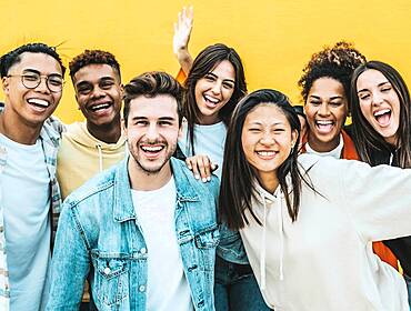 Multiracial group of young people laughing looking at the camera.