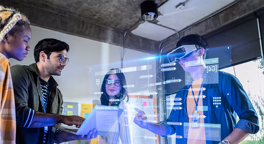 Four diverse STEM employees work with AI and VR technology.