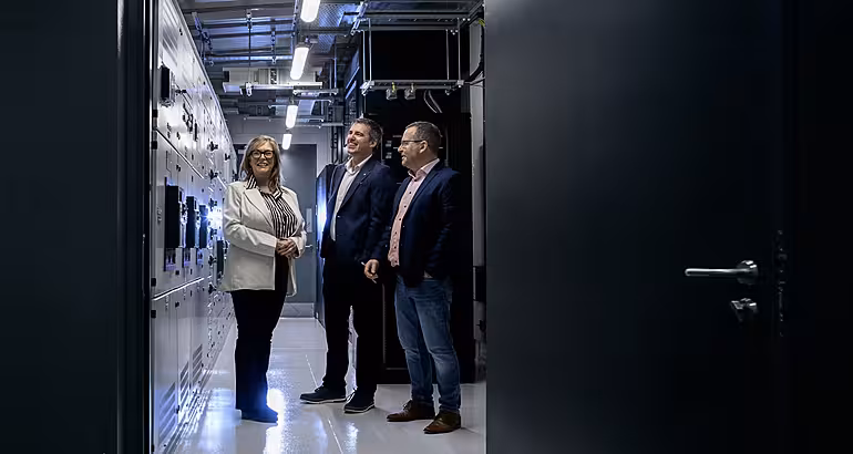Dymphna Conlon, John Moran and Martin Winters pose in a hallway at Suretank.