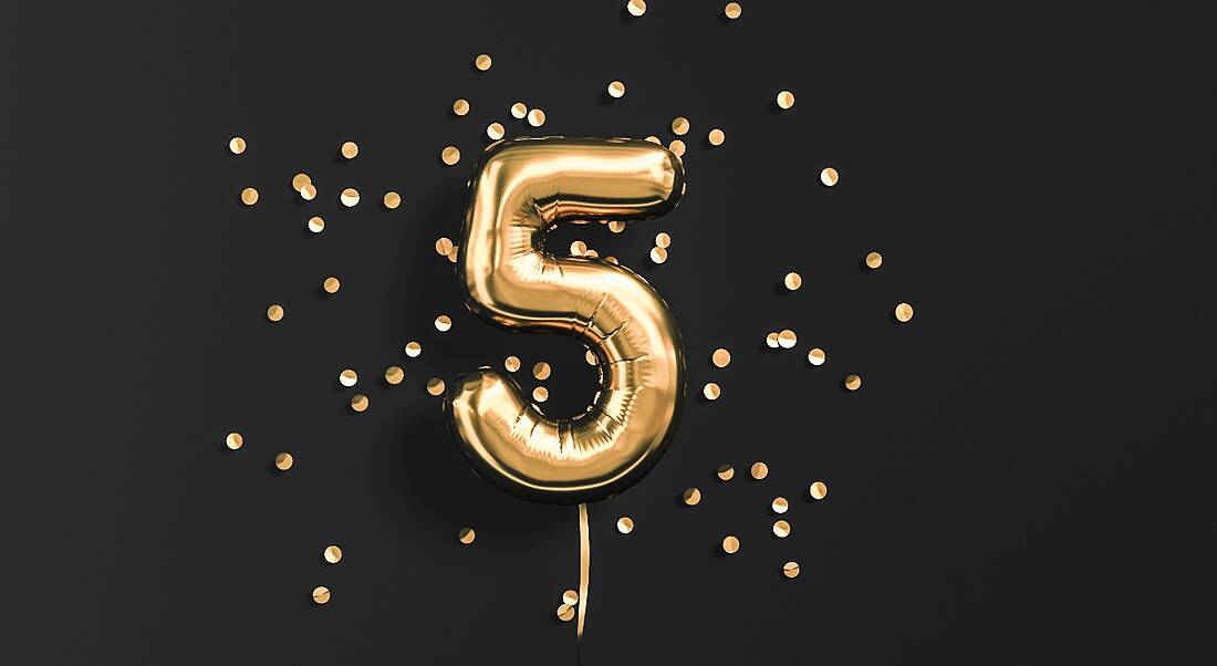 Foil number 5 balloon in gold against a black background.