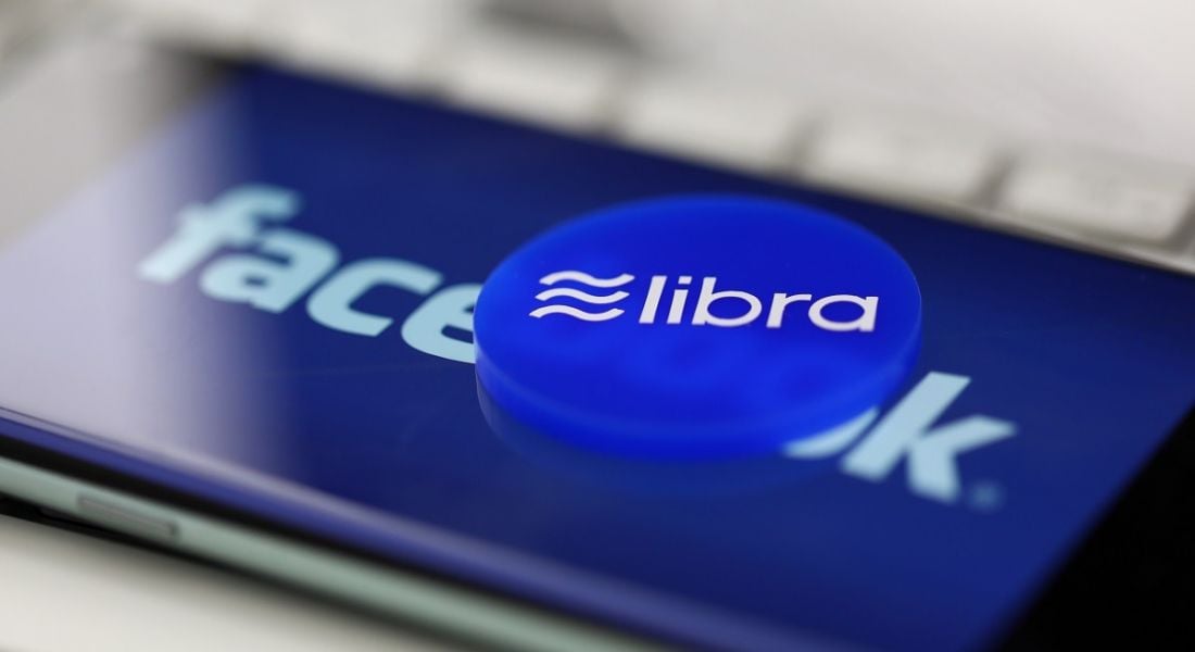 Badge with Libra logo on a phone with the Facebook logo on screen.