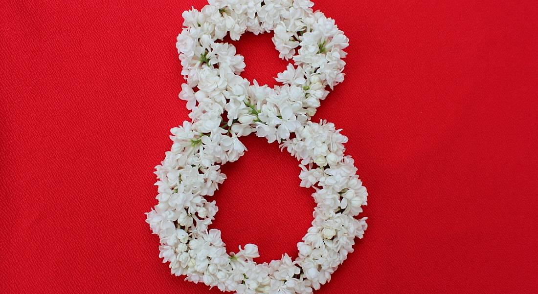 The number 8 is arranged in flowers against a red background.