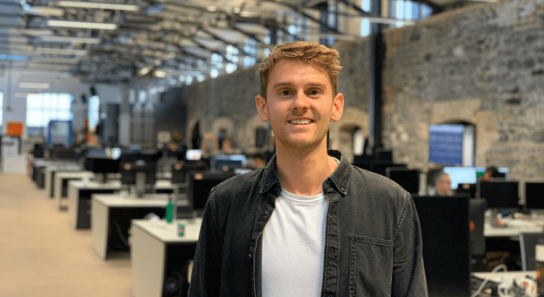 Mark Murray of Zalando is standing in the Dublin tech hub's office and smiling into the camera.