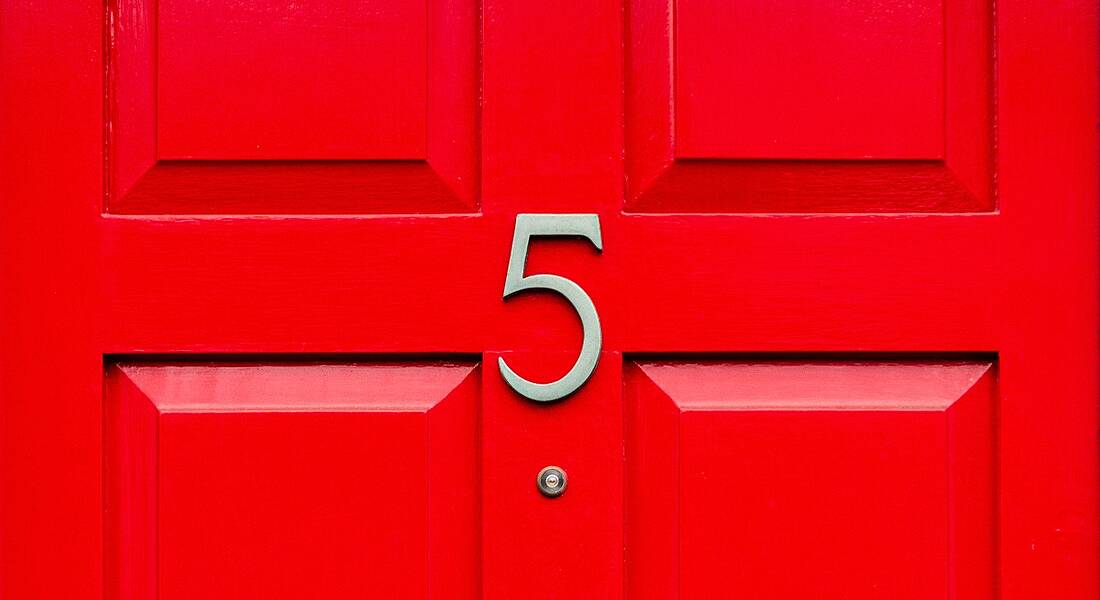 A gold number 5 on a bright red front door.