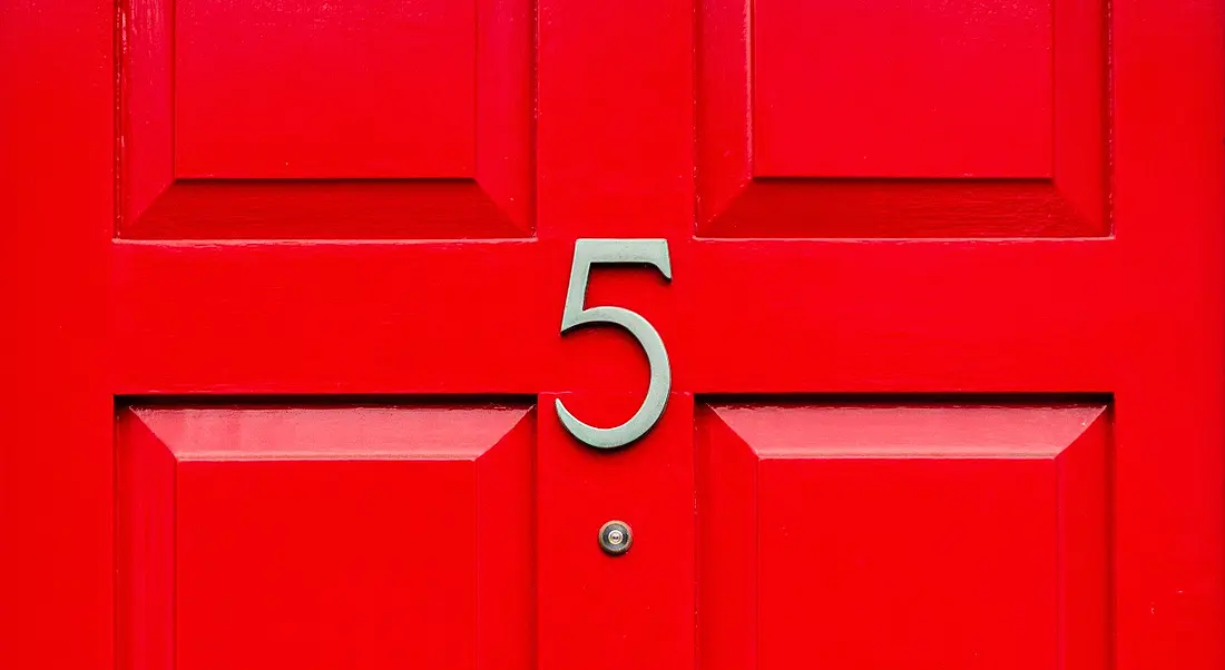 A gold number 5 on a bright red front door.