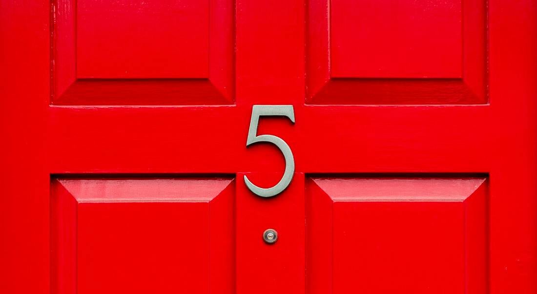 A gold number 5 on a bright red front door.