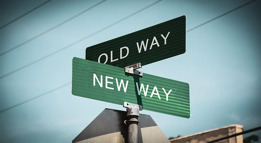 Two street signs reading 'old way' and 'new way' against a bright blue sky.