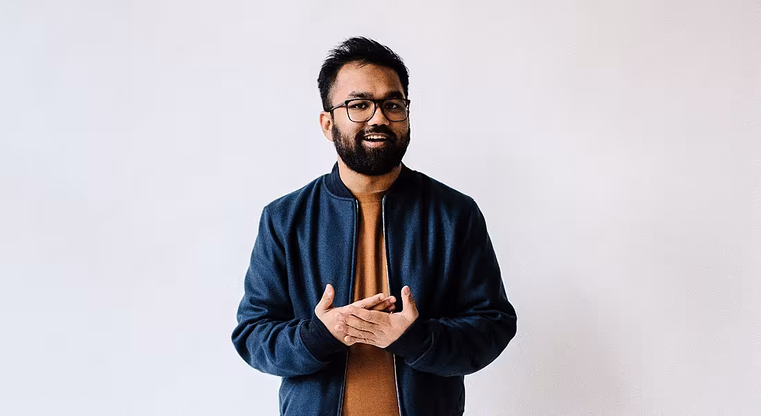 Rousseau Kazi of Threads is standing against a white background wearing casual clothes.