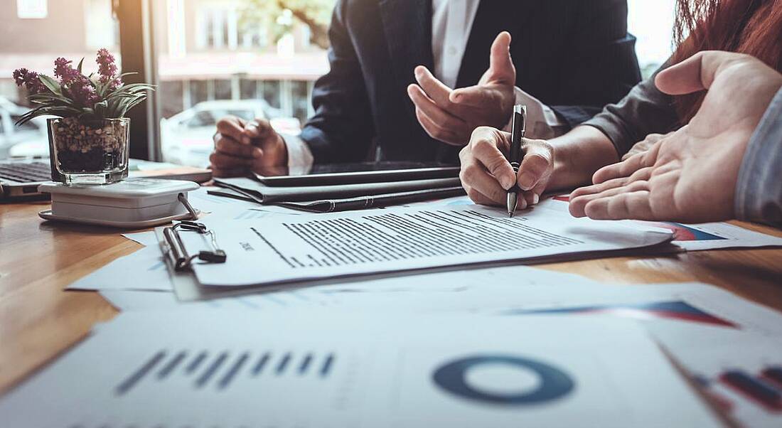 Colleagues are working together at a table in a professional services firm.