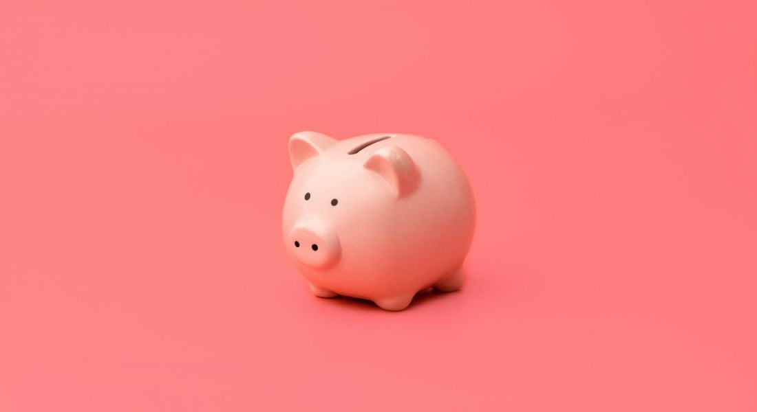Pink piggy bank against a pink background.