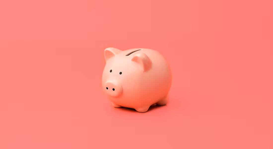 Pink piggy bank against a pink background.