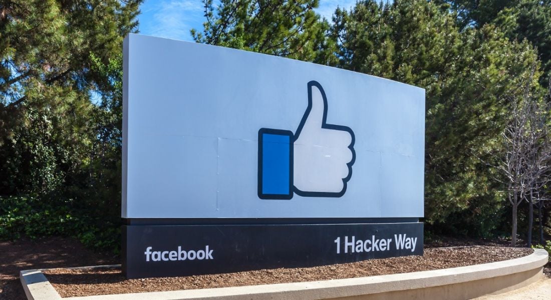 An outdoors sign with with Facebook branding in the US against a clear blue sky.