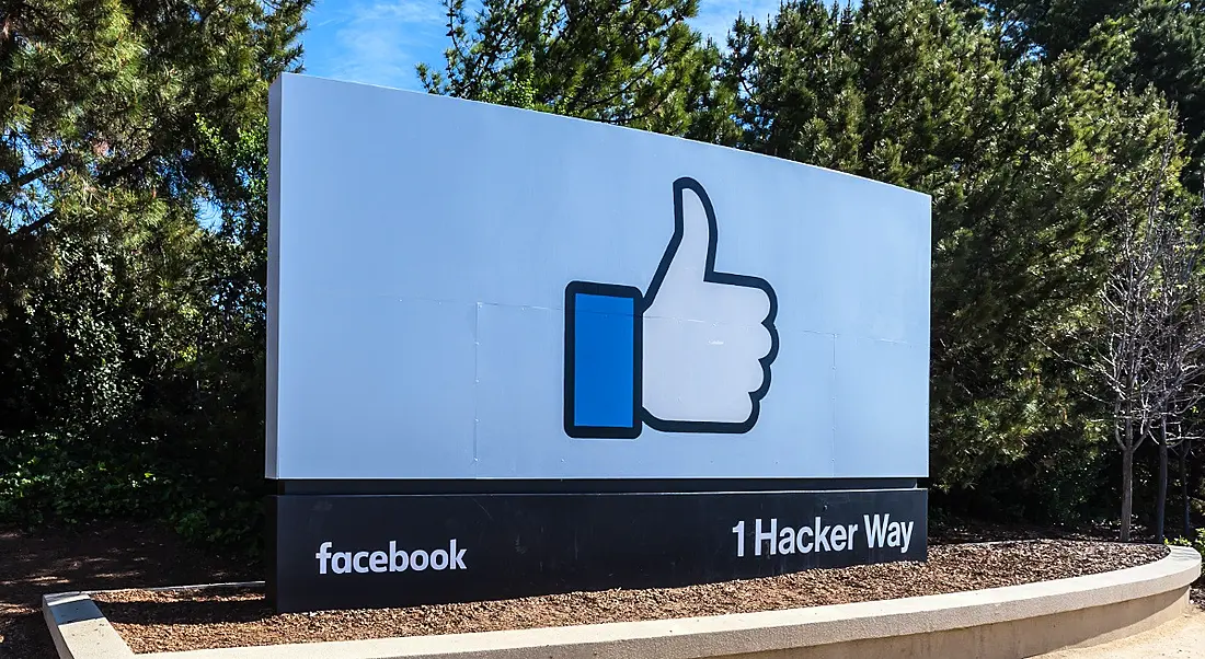 An outdoors sign with with Facebook branding in the US against a clear blue sky.