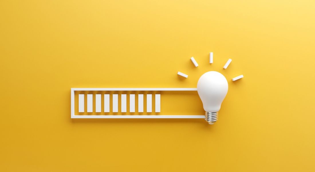 A white loading bar leading to a light bulb against a yellow background.