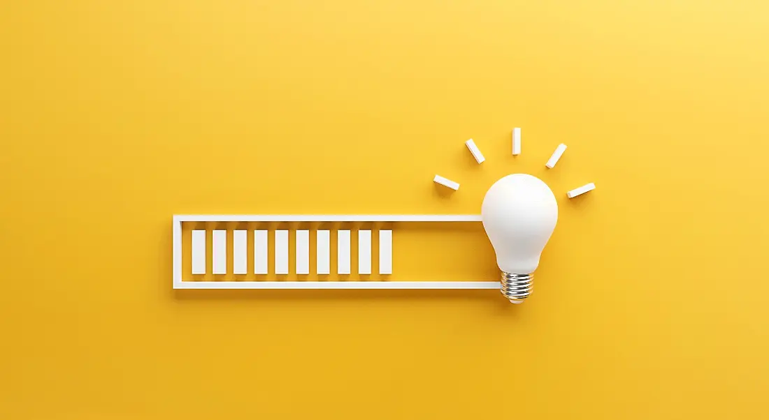 A white loading bar leading to a light bulb against a yellow background.