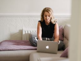 Businesswoman speaking on video call with diverse colleagues on her laptop from home.