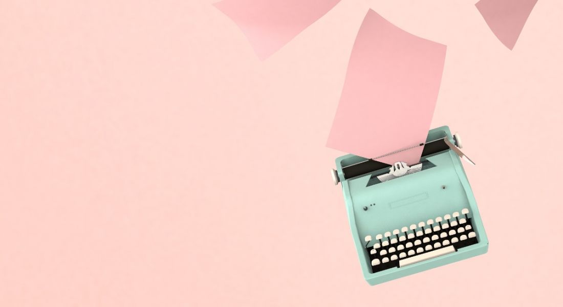 Retro blue typewriter with paper sheets on pink background, symbolising CV updates.