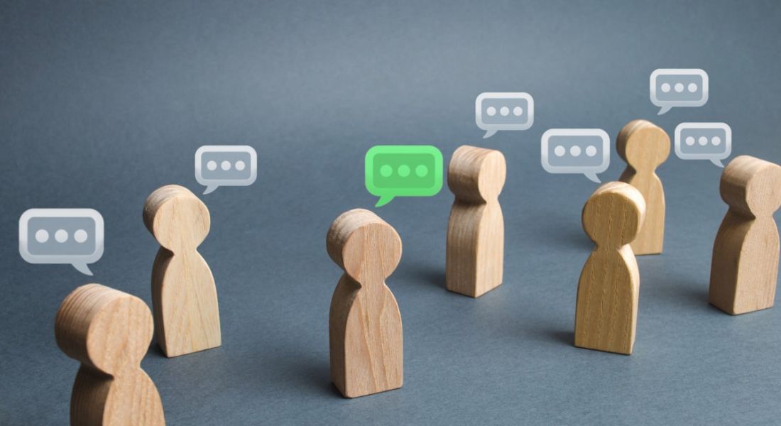Small wooden figures have speech bubbles over their heads on a grey background.