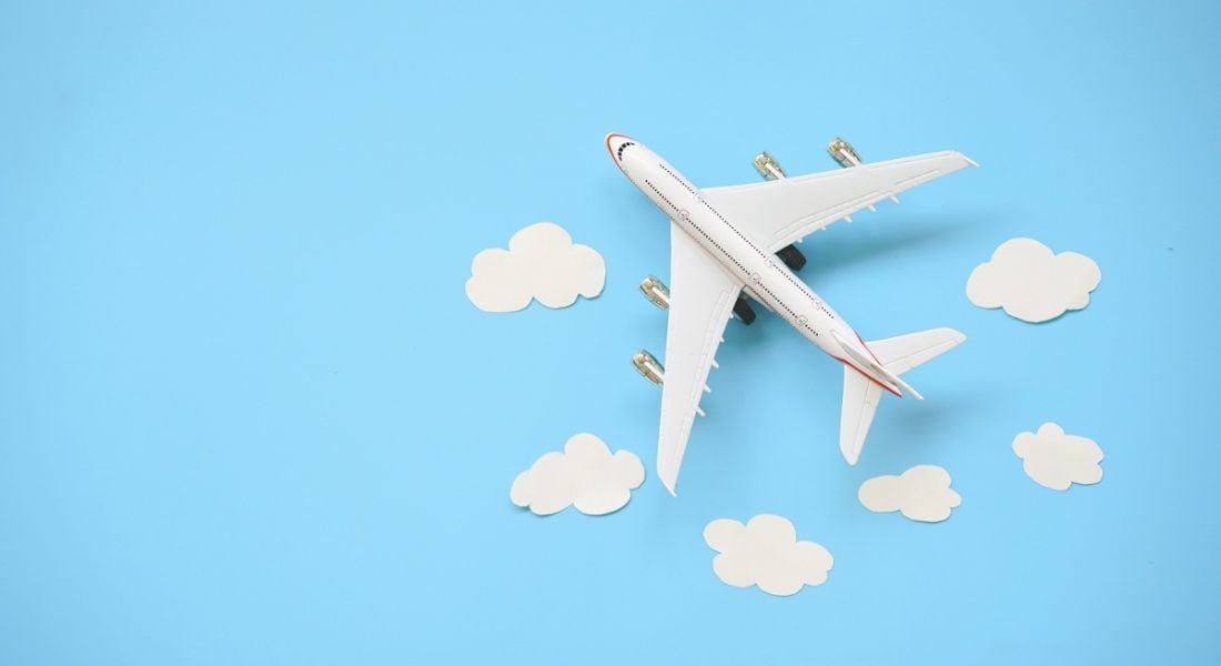 Toy airplane and white clouds on blue background.