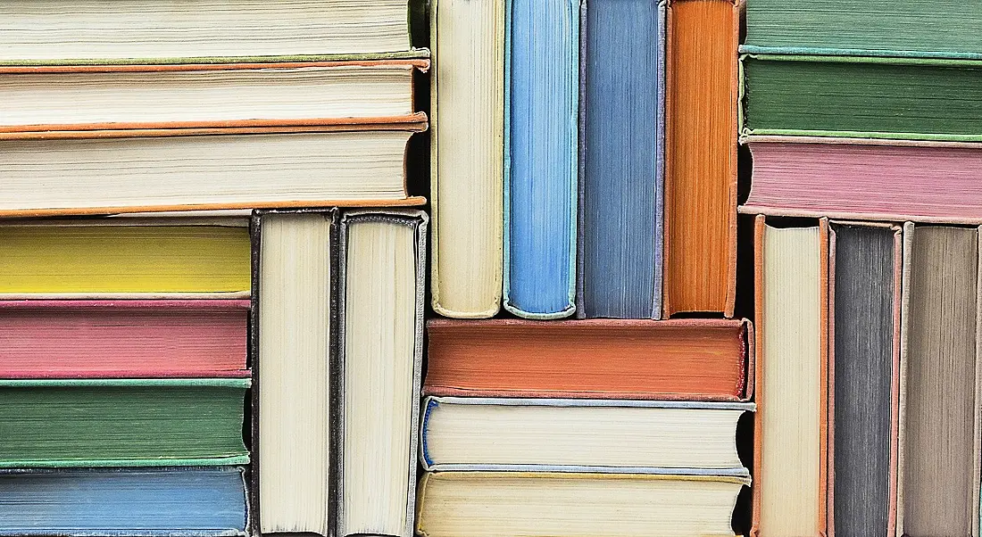 Stacks of books in different colours, symbolising lifelong learning.