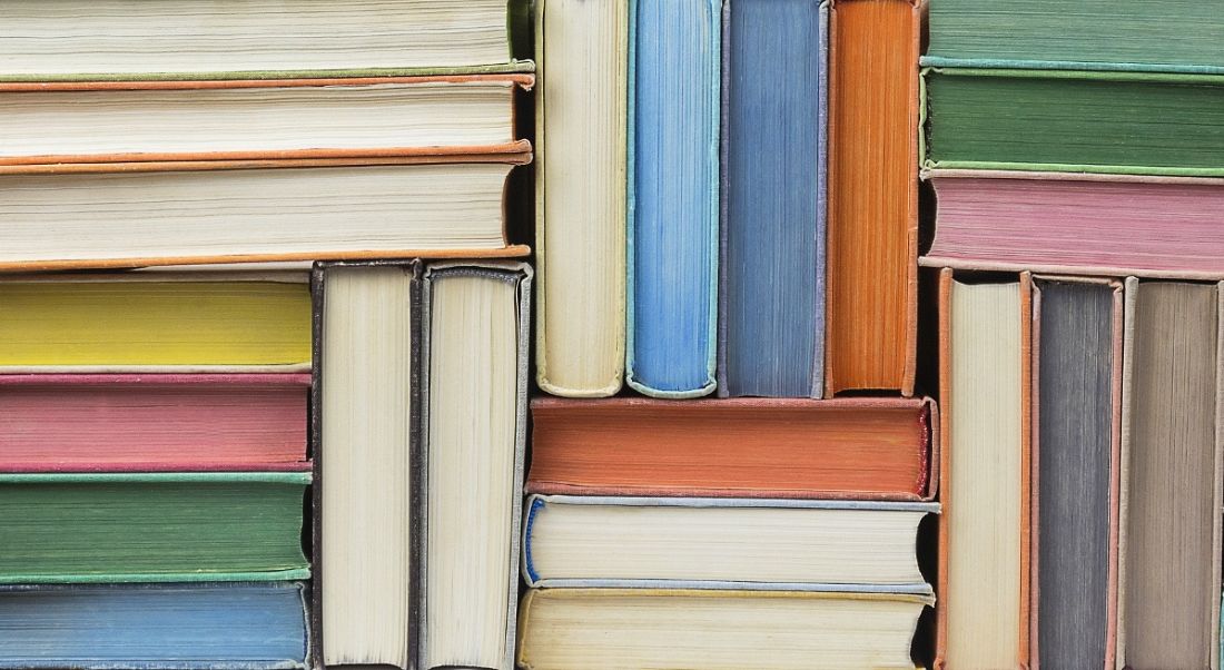 Stacks of books in different colours, symbolising lifelong learning.