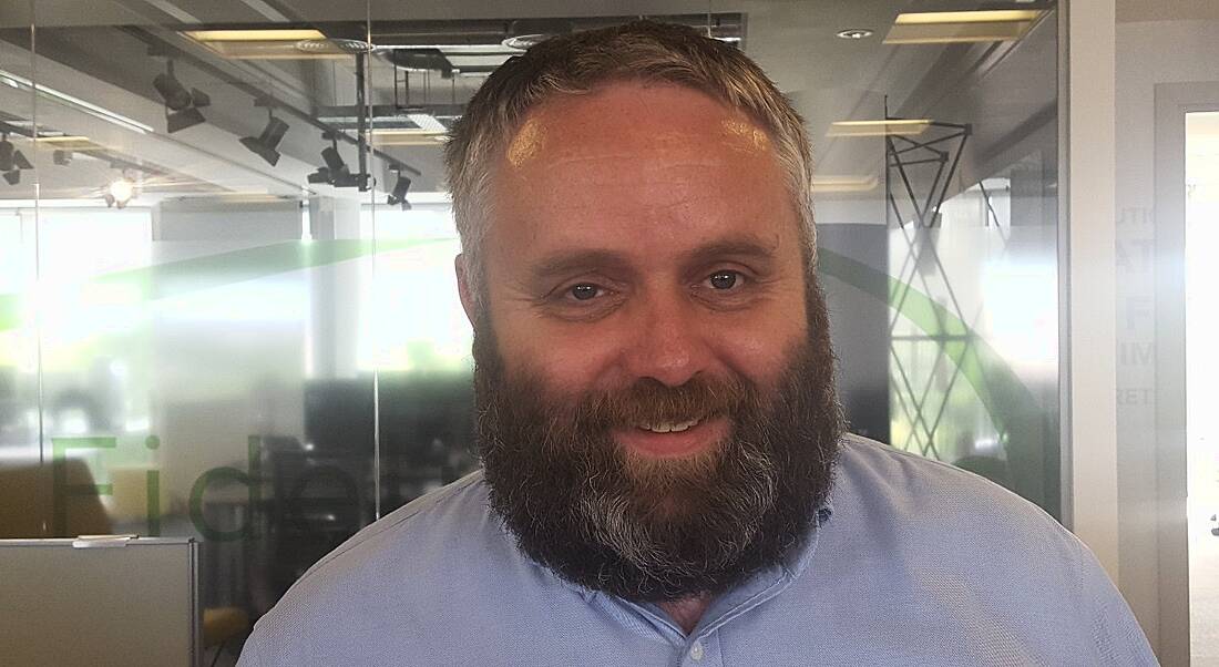 John Farrelly of Fidelity Investments is smiling into the camera in the company's office.