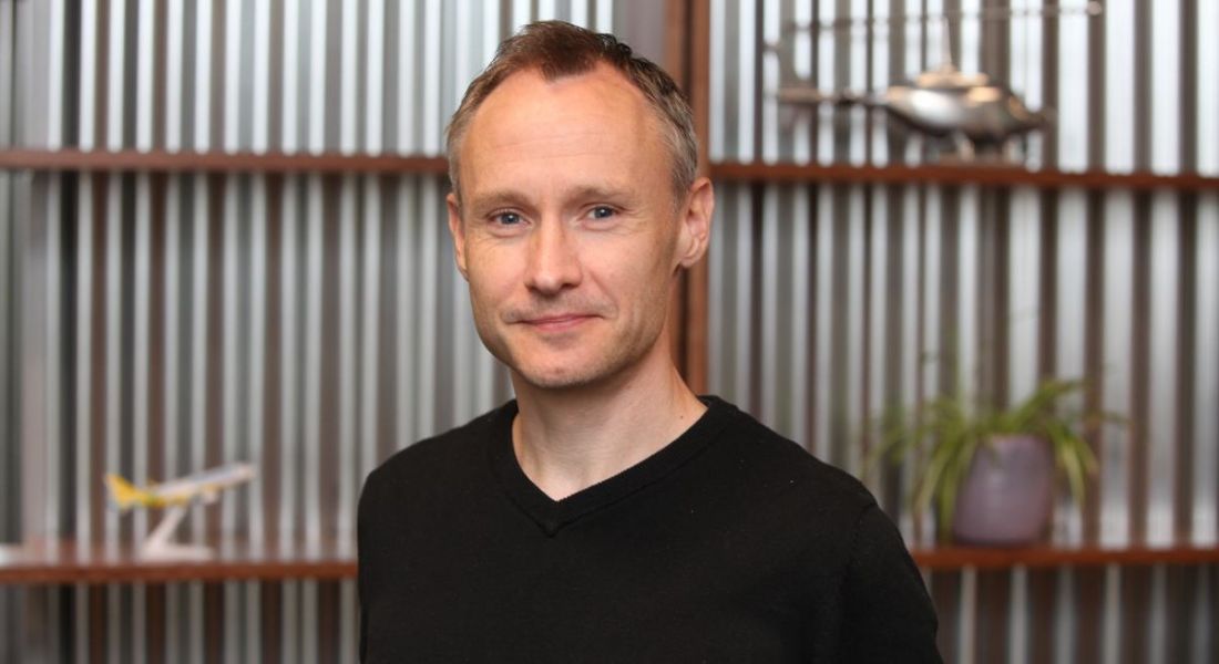 Breffni Murdoch of Viasat Ireland is smiling into the camera, standing in front of a contemporary office backdrop.