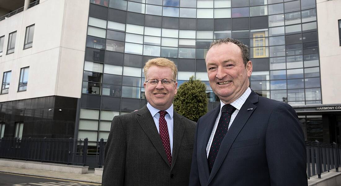 Peter Rose and Nick Connors from Tekenable are standing outside a modern building in Dublin, smiling into the camera.