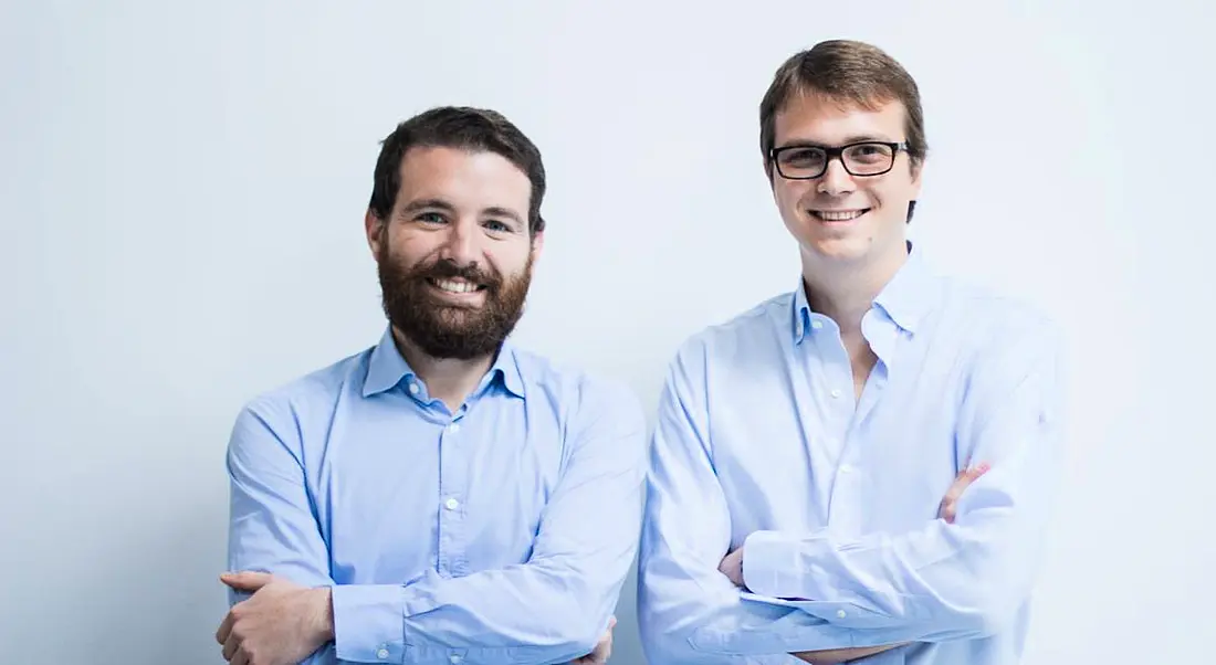 The co-founders of LogoGrab are standing together and smiling into the camera.