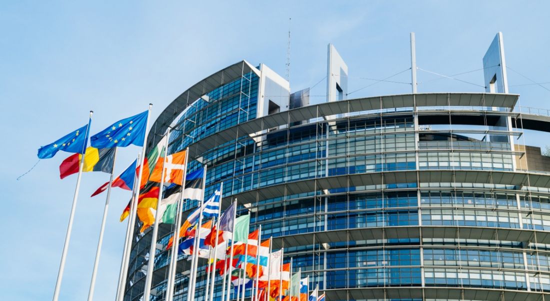 Flags of EU member states are floating in the breeze outside EU buildings.