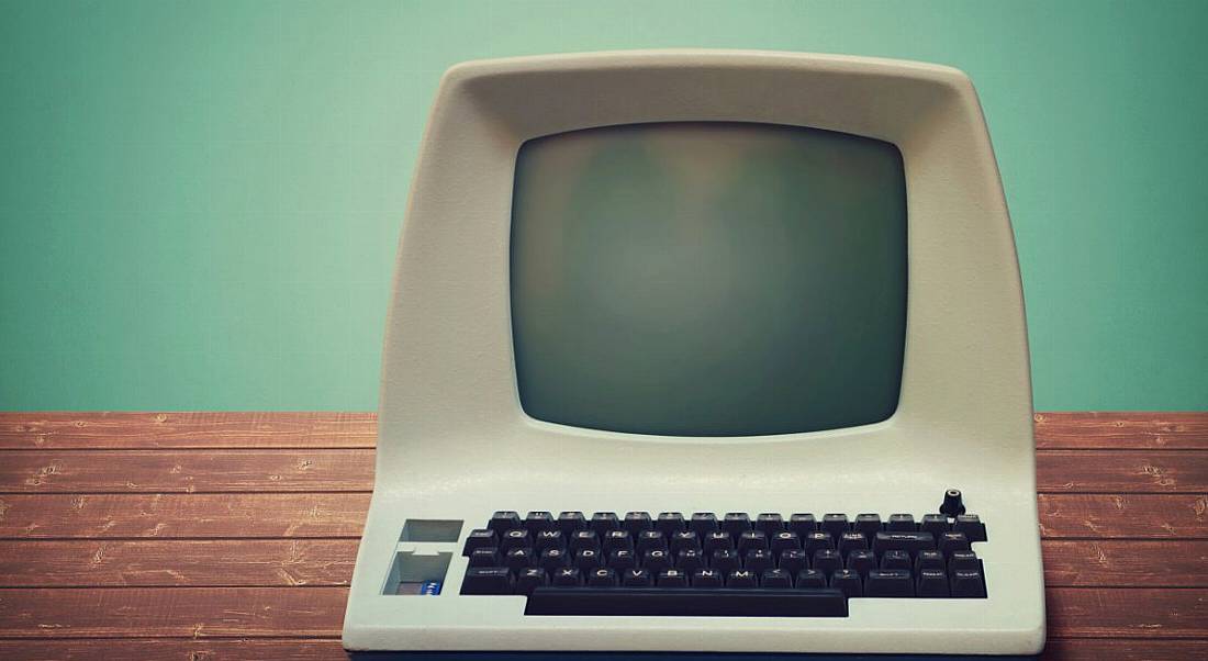 Old computer on a wooden table.