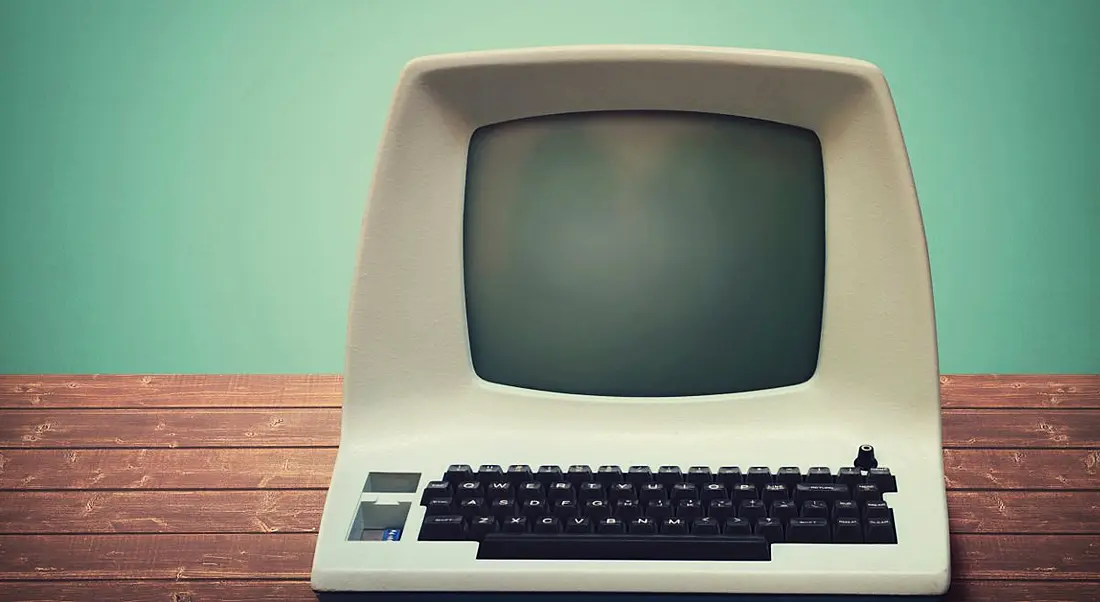 Old computer on a wooden table.