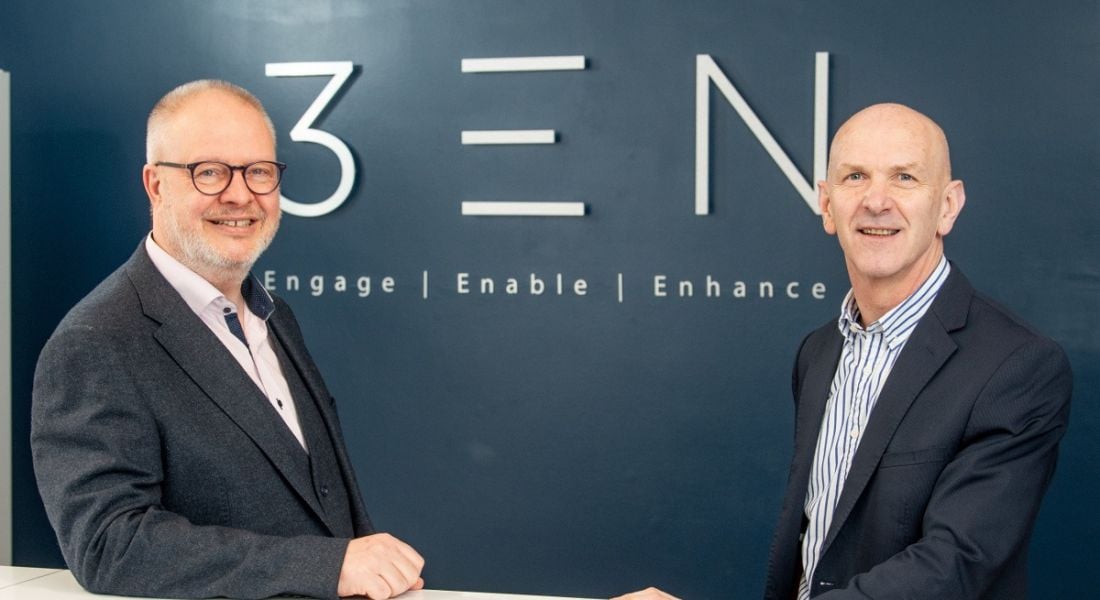 Two men in suits are standing in front of a 3EN-branded wall and smiling into the camera.