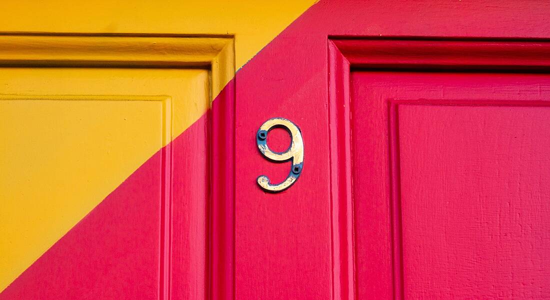 Number 9 on a pink and orange front door.