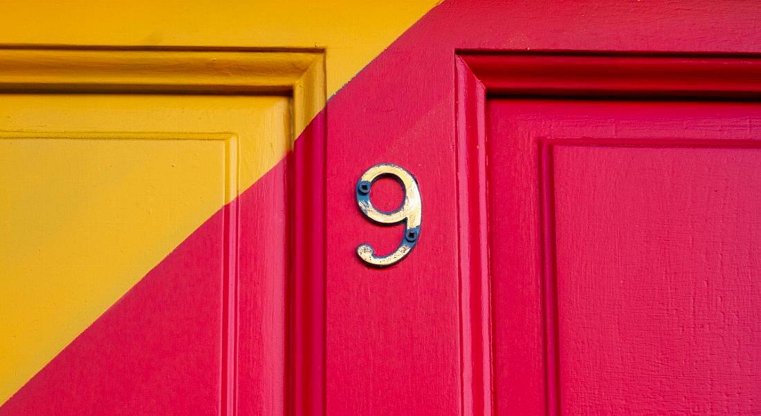 Number 9 on a pink and orange front door.