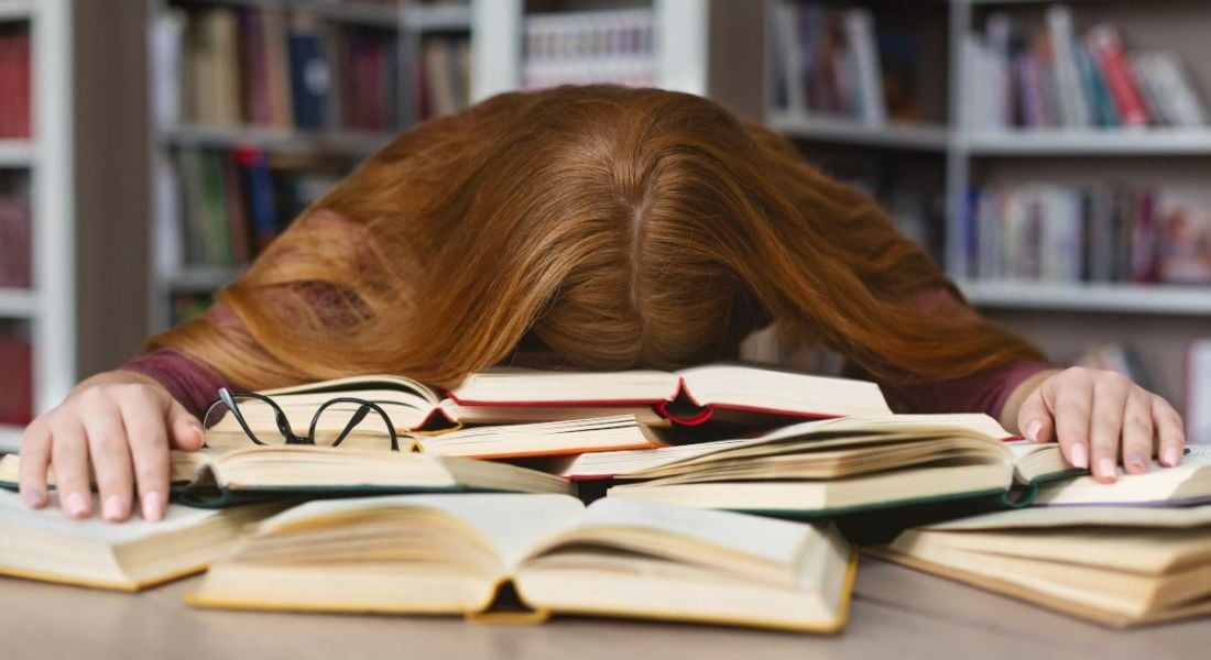 Girl studying at desk and sleeping on books.