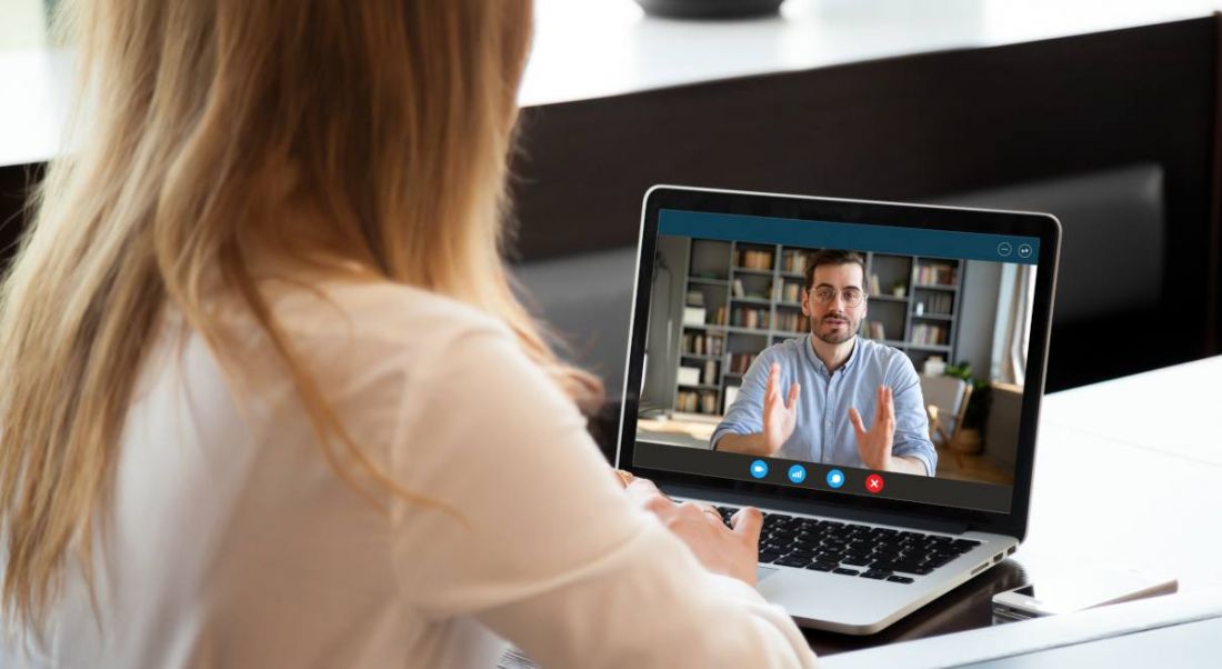 View over shoulder of employer conducting a remote interview using video conferencing technology.