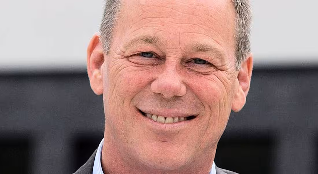 Andrew Brown is smiling into the camera in an outdoor setting.