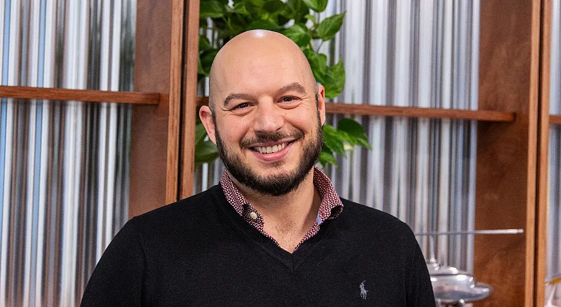 DevOps engineer at Viasat Ireland, Adrian Fachal, is smiling into the camera at the company's Dublin office.