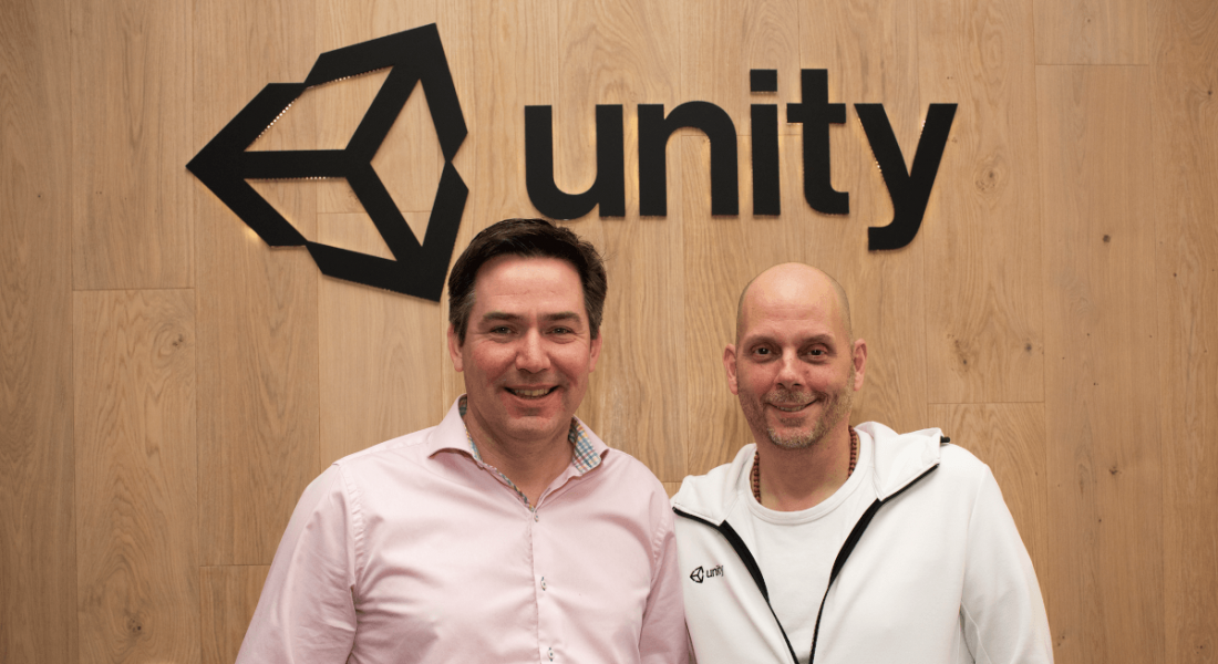 Two men standing in front of the Unity logo.