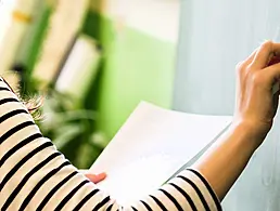 Young businesswoman looking deep in thought while sitting at her desk in a large modern office working online with a laptop.