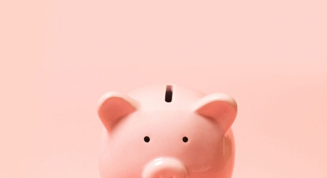 Piggy bank on light pink background symbolising Covid-19 impacts on tax for workers.