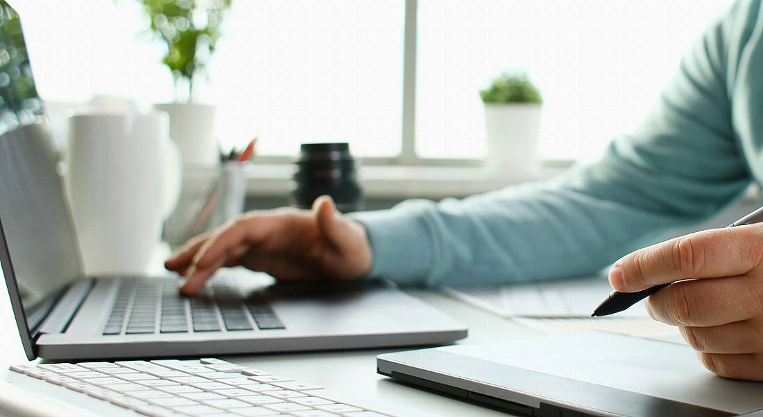 A person is using a laptop at a desk, learning and upskilling.