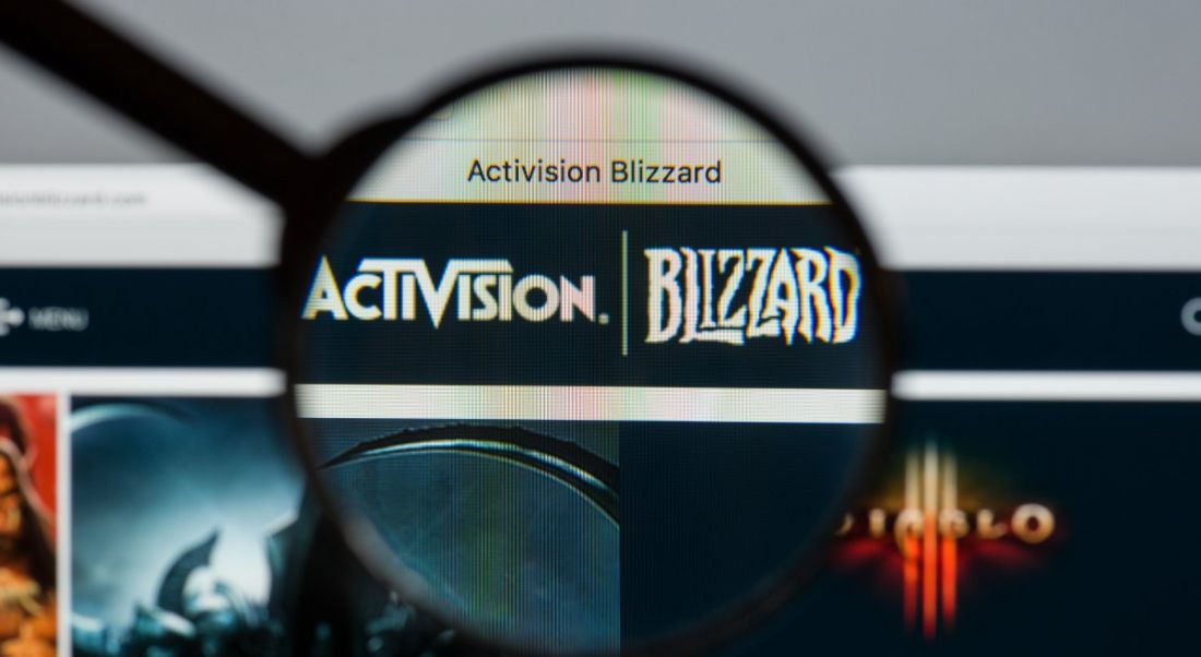 Activision Blizzard website homepage with logo under a magnifying glass.