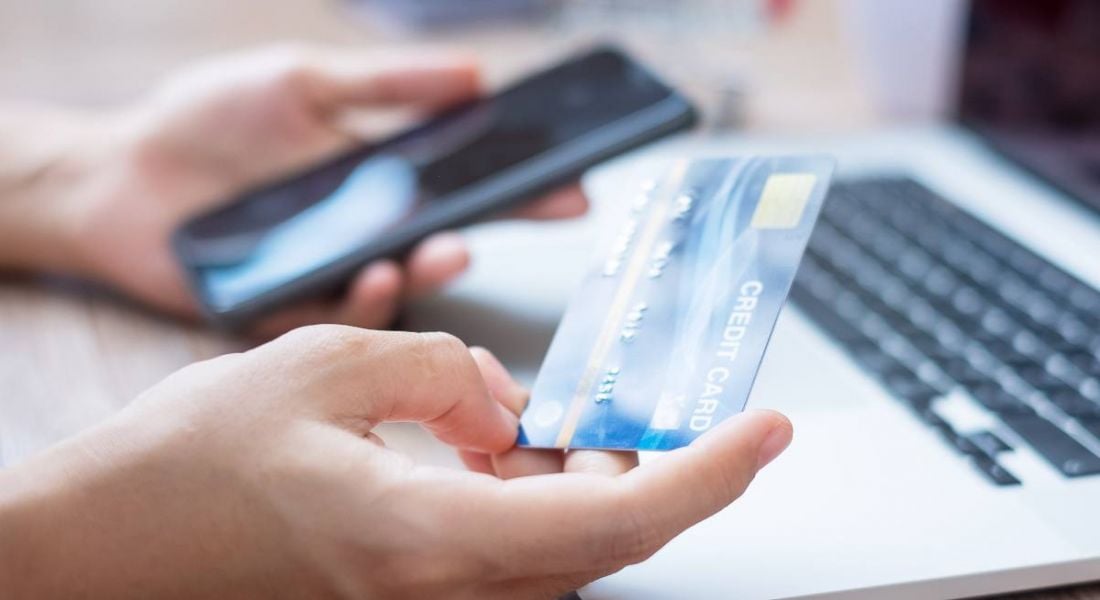 Close-up of a person holding a credit card up to a smartphone.